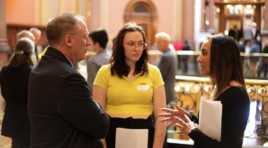 Maggie Schnurr and Payton Colbert discuss their research with state legislator.