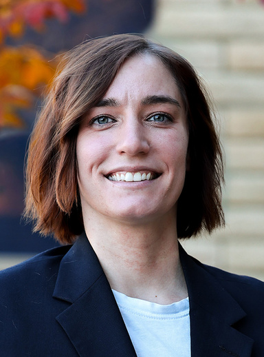 Headshot of Juliana Lucchesi wearing a white blouse and blue suit. 