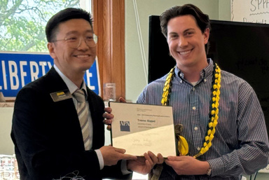 Haifeng Qian presents framed award to Trevor Sippel at the SPPA commencement reception. 