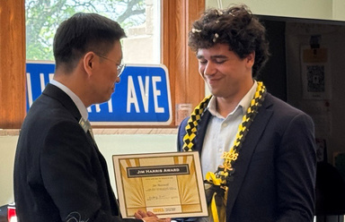 Joe Maxwell receiving framed award from Haifeng Qian during SPPA commencement reception