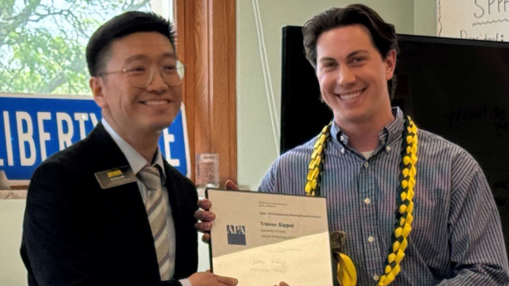 Haifeng Qian presents framed award to Trevor Sippel at the SPPA commencement reception. 